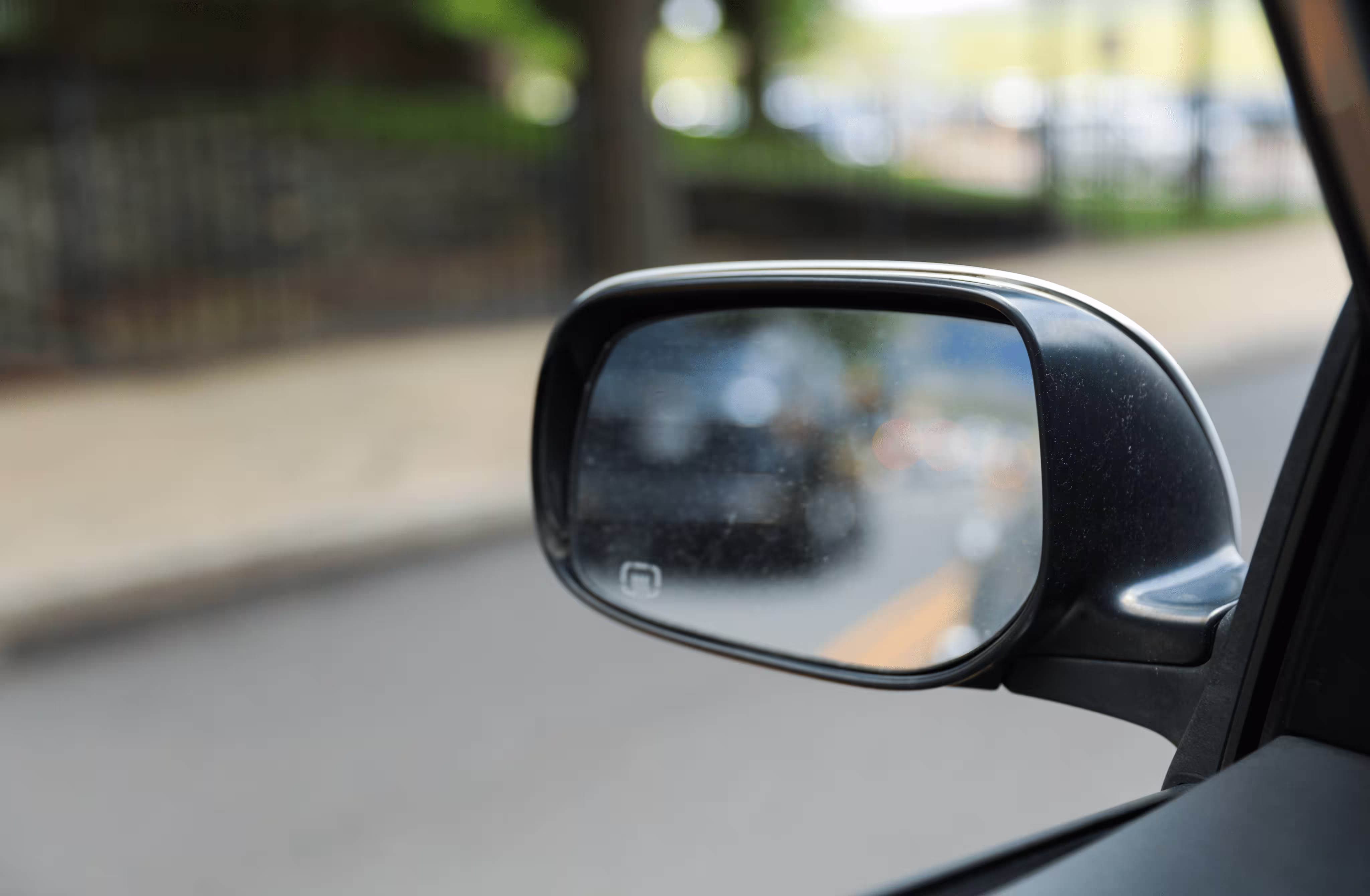 Side mirror showing a car in the blind spot in Pharr lane change accidents.